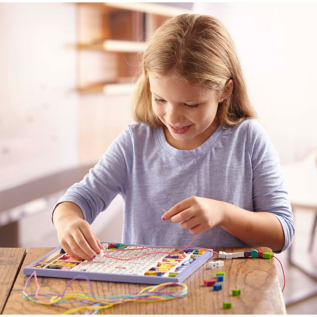 kind speelt met houten letterkralen