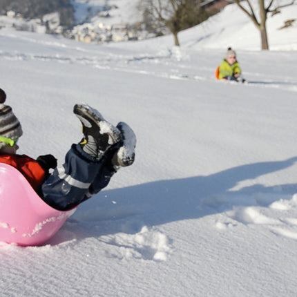 kind speelt met roze Bilibo in de sneeuw