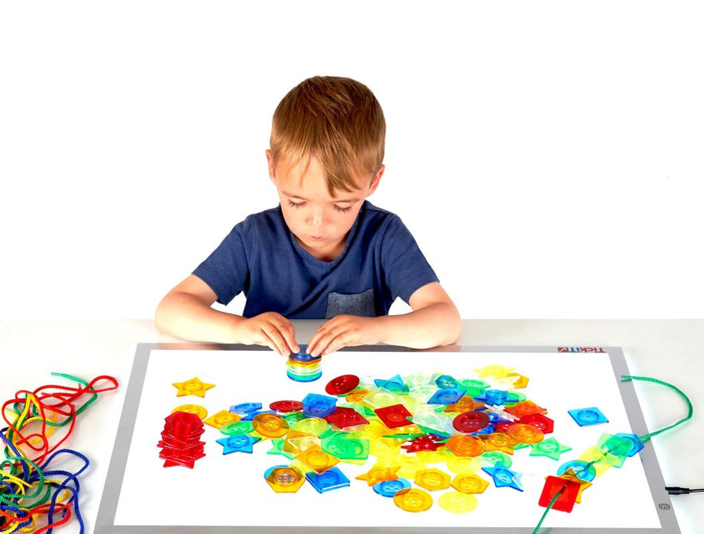 kind speelt met stapelbare knoppen op een lichtpaneel