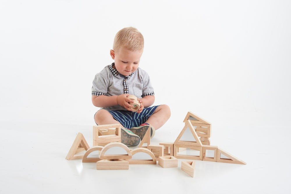 peuter speelt met houten spiegelblokken