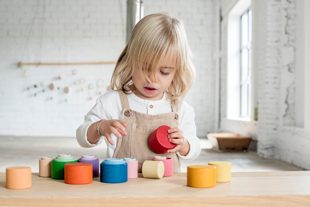 peuter speelt met de nest schaaltjes en steekt ze in elkaar