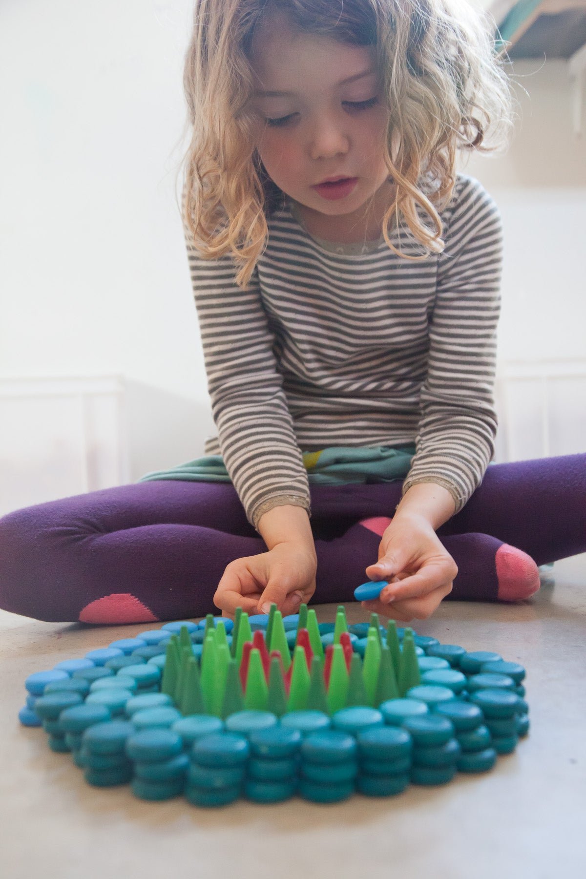 kind maakt houten mandala