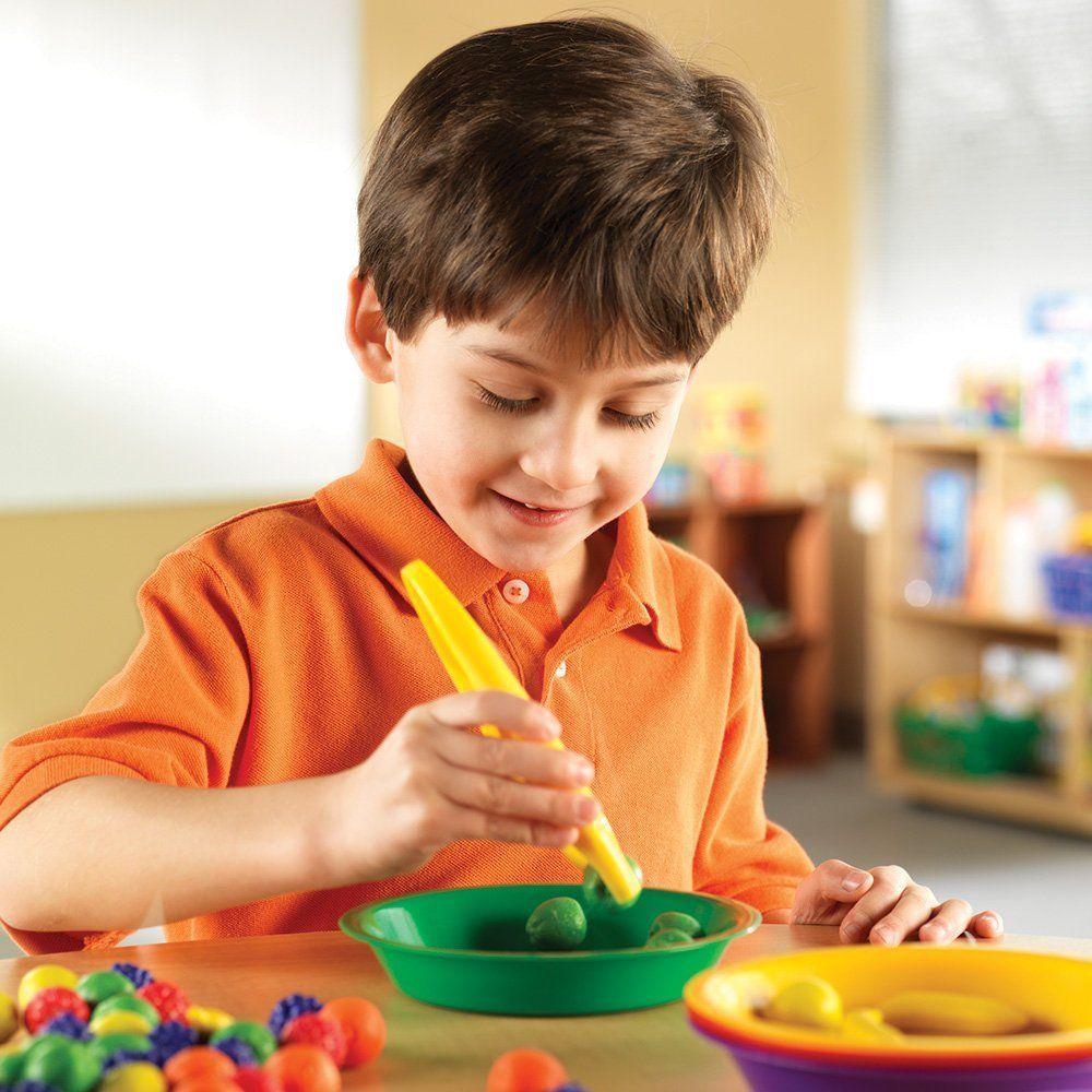 kind speelt met Learning Resources 12 jumbo tweezers